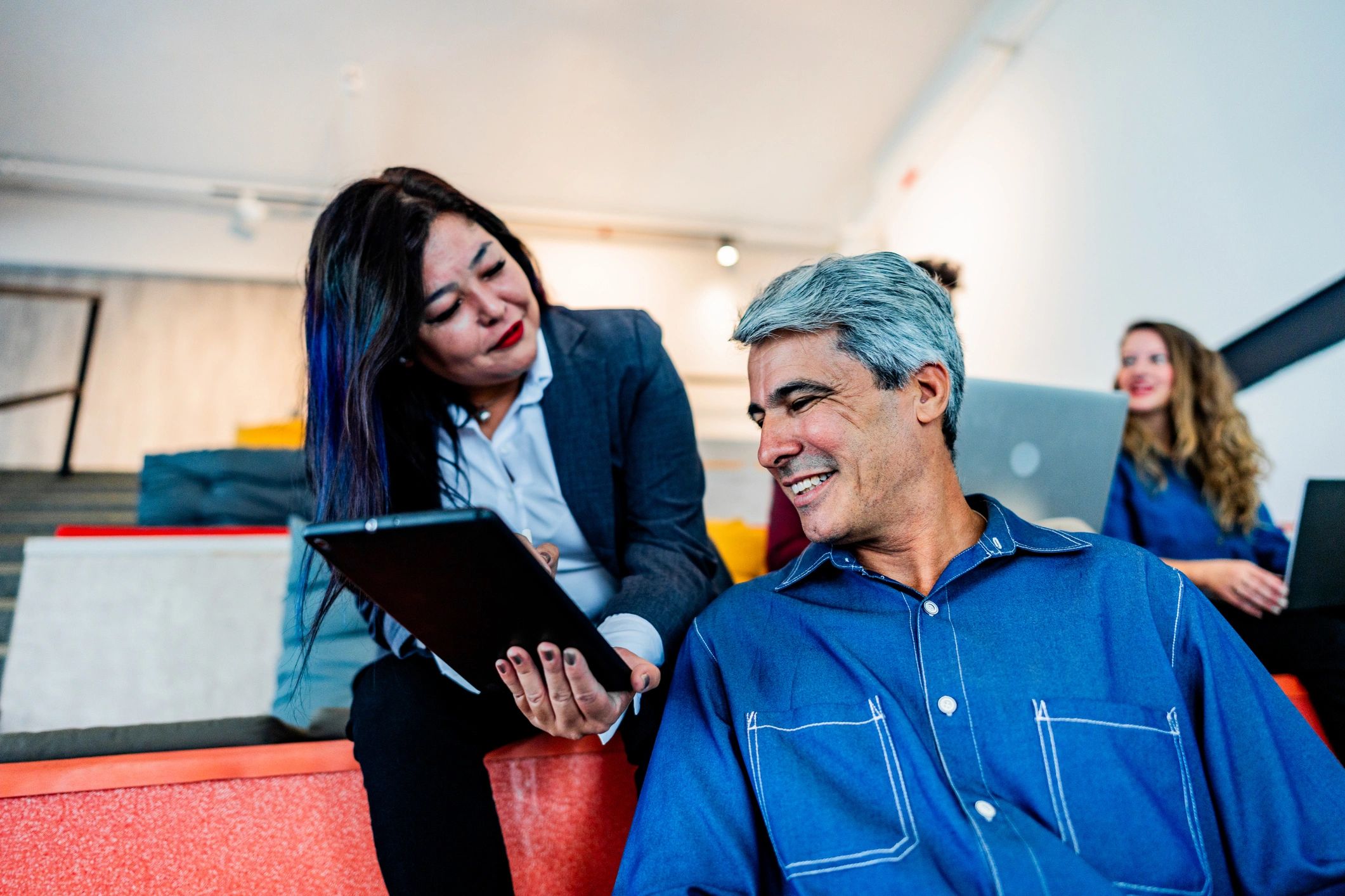 Advisors collaborating over a digital tablet in an office